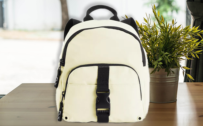 FLX Mini Top Zip Backpack in Light Yellow on a Table