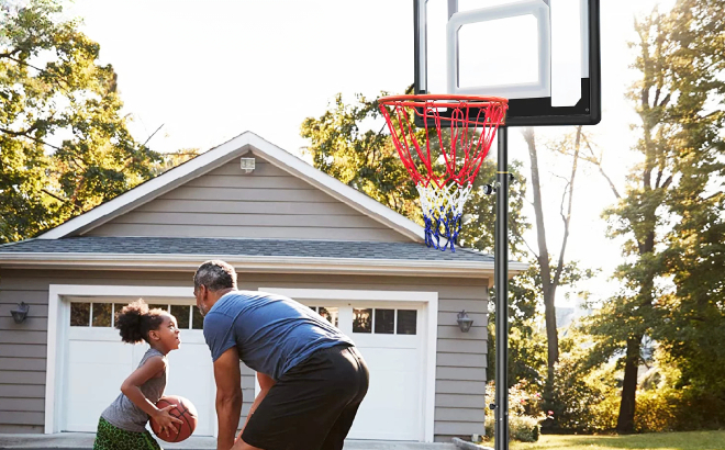 Father and Daughter Playing with Portable Basketball Hoop System