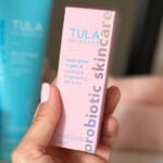 Hand Holding Tula Skincare Rose Glow Get It Cooling Brightening Eye Balm