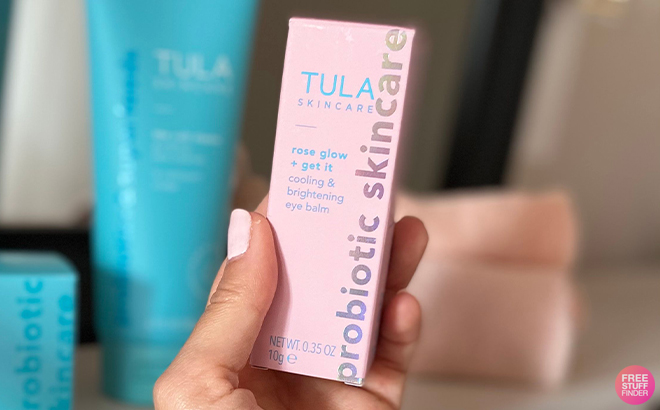 Hand Holding Tula Skincare Rose Glow Get It Cooling Brightening Eye Balm