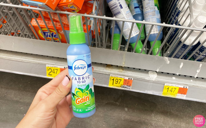 Hand Holding a Bottle of Febreze Fabric Refresher To Go Gain Spray