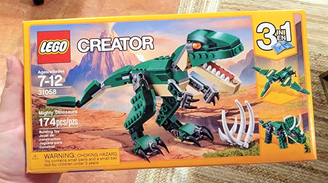 Hand holding LEGO Creator 3 in 1 Mighty Dinosaur Toy