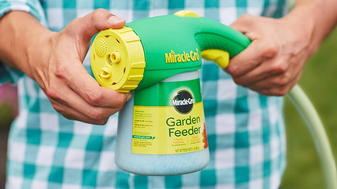 Hands Holding Miracle Grow Feeder