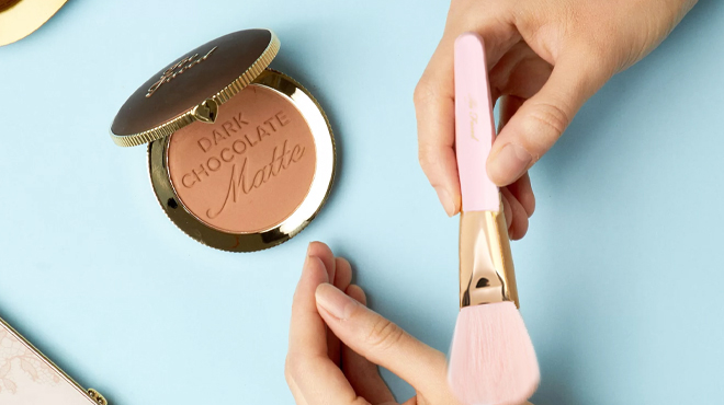 Too Faced Chocolate Soleil Matte Bronzer a person holding the Powder Brush Set