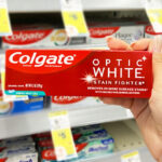 a Hand Holding Colgate Optic White Toothpaste