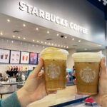 a Person holding a Starbucks cup of coffee