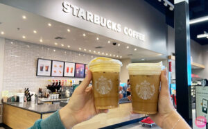 a Person holding a Starbucks cup of coffee