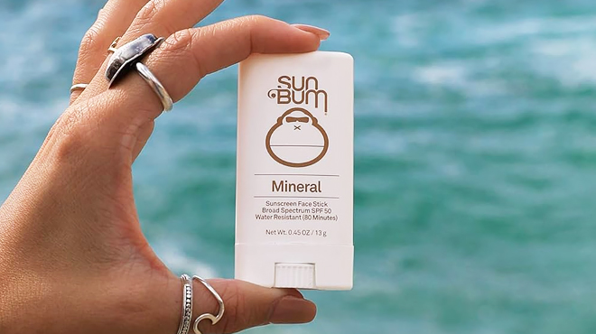 A Hand Holding Sun Bum Mineral SPF 50 Sunscreen Face Stick