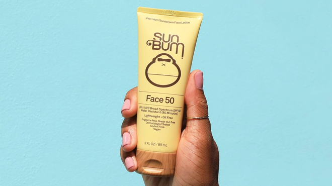 A Hand Holding Sun Bum Original SPF 50 Sunscreen Face Lotion