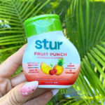 A Person Holding Stur Fruit Punch Water Enhancer