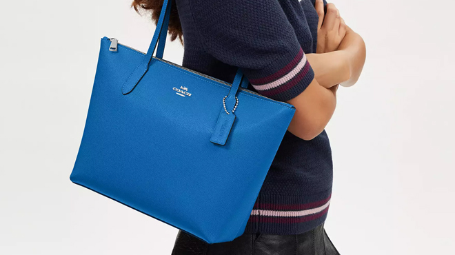 A Person Wearing Blue Coach Tote Bag