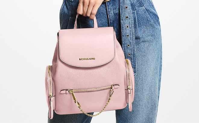 A Person is Holding Michael Kors Jet Set Medium Pebbled Leather Backpack in Powder Blush Color