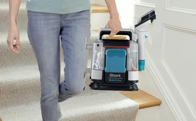 A Person is Holding Shark StainStriker Portable Carpet Upholstery Cleaner with Tools