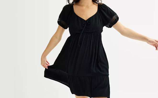 A Person is Wearing Juniors Pink Republic Crochet Sleeve Skater Dress in Black Color