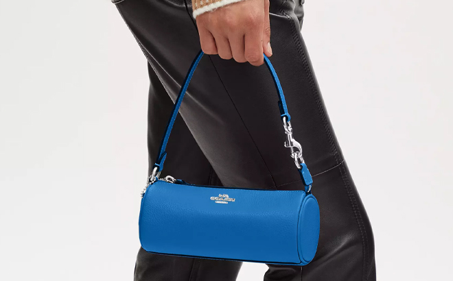 A Woman Holding Coach Outlet Nolita Barrel 19 Bag in Bright Blue