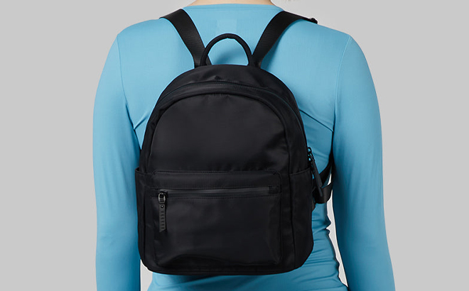A Woman Wearing 32 Degrees Mini Backpack in Black Color