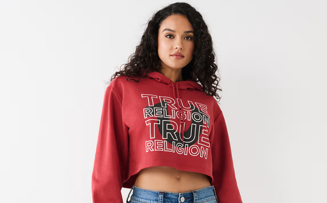 A Woman Wearing True Religion Womens Logo Crop Hoodie in Ruby Red Color