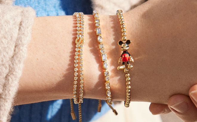 A person wearing various bracelets including Disney 3D Character Pisa Bracelet