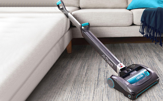 Bissell AirRam Cordless Vacuum in Teal Color Next to a Couch