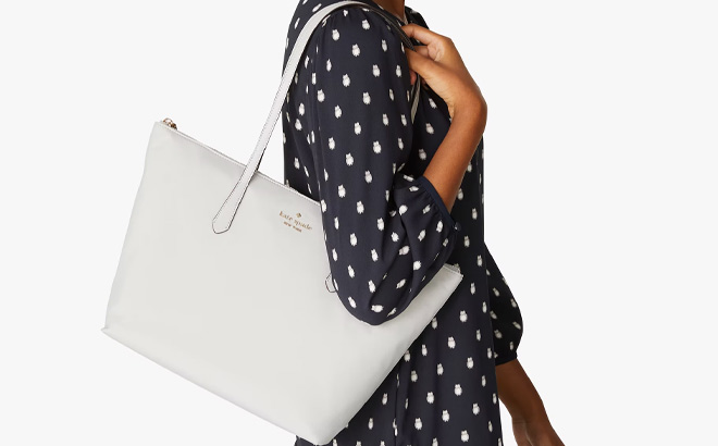 Hand Holding Kate Spade Kitt Large Tote in Platinum Grey Color