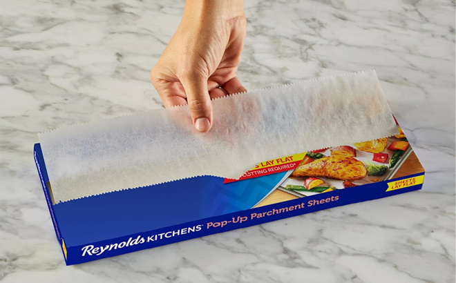 Hand Holding Reynolds Kitchens Pop Up Parchment Paper Sheets