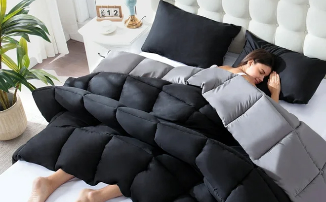 WhatsBedding 3 Pieces Bed in a Bag Comforter Set on a Bed in the Color Black with a Person Sleeping Under It