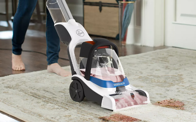 A Person Holding Hoover PowerDash Pet Compact Carpet Cleaner