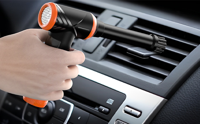 A Person Holding Hotfien Compressed Air Duster in Vibrant Orange Color