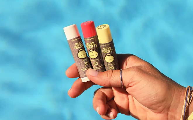 A Person Holding Three Sun Bum SPF Lip Balm Sticks