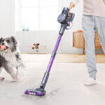 A Person Using the Lubluelu Cordless Vacuum Cleaner in a Room with a Dog Next To It