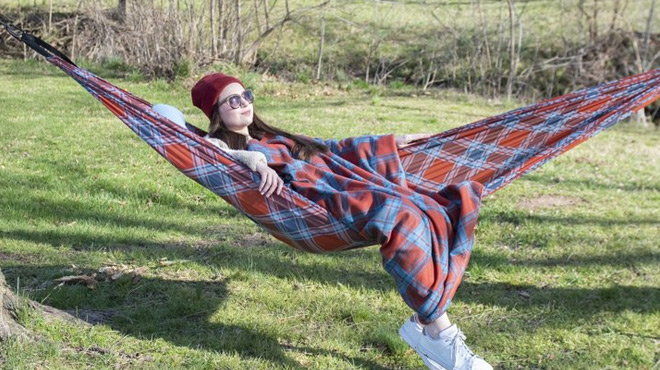 A Person resting on a Equip Bundle Nylon 1 Person Hammock with Blanket