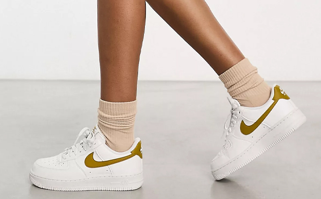 A Woman Wearing Nike Air Force 1 '07 SE Sneakers in White & Gold