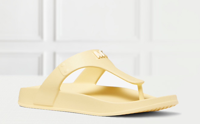 Michael Kors Linsey Logo Rubber T Strap Sandal in Buttercup Color on the Table