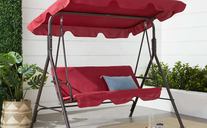 A 2 Person Outdoor Canopy Swing Glider in burgundy color