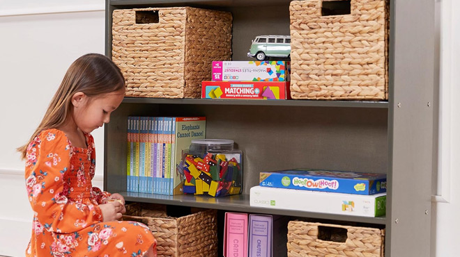 A Child Sitting beside a ECR4Kids 3 Shelf Storage Cabinet