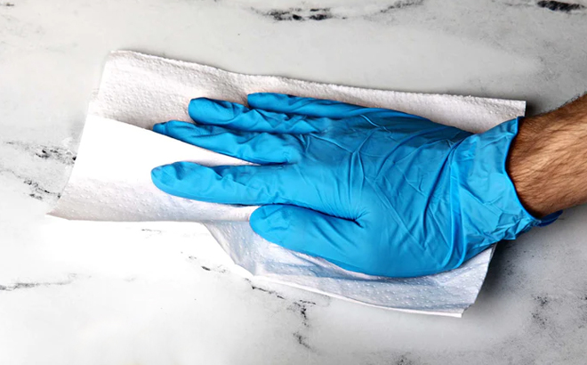 A Man Cleaning a Marble Countertop Using 4Mil Blue Nitrile Gloves