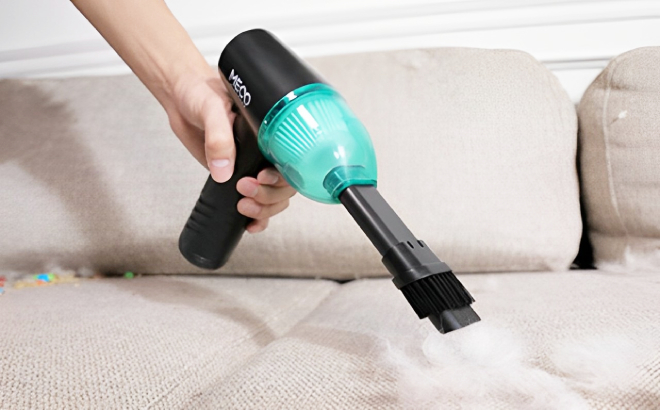 A Person Cleaning Fur on Couch Using Meco Elverde Compressed Air Duster Mini Vacuum Cleaner