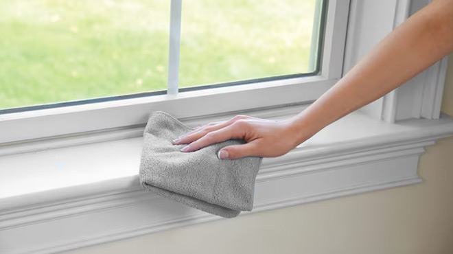 A Person Cleaning a Window Using a Rubbermaid 24 Pack Microfiber Cloth