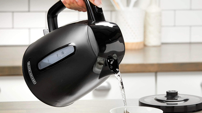 A Person Pouring Water from a BlackDecker Electric Kettle