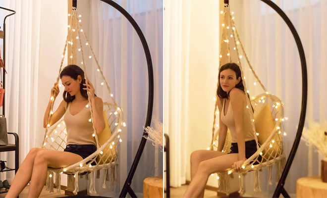 A Person Sitting in the Dakota Fields Armstong Hanging Porch Swing with 39 Feet Long LED Lights