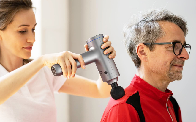 A Person a Mans Shoulder Using Mebak 5 Percussion Massage Gun