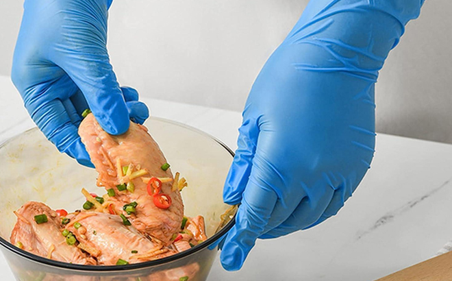 A Woman Marinating Meat Using 4Mil Blue Nitrile Gloves