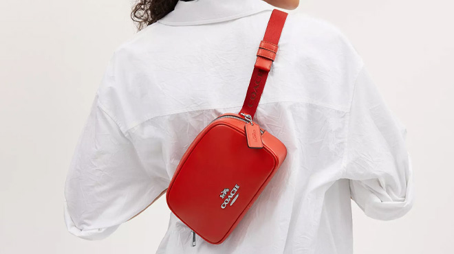 A Woman Wearing Coach Outlet Pace Belt Bag in Miami Red