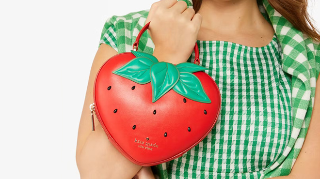 A lady holding a Kate Spade Strawberry Dreams 3D Strawberry Crossbody