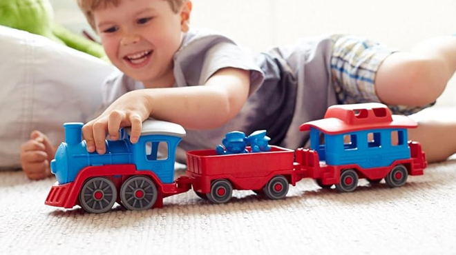 A Boy PLaying Green Toys Train