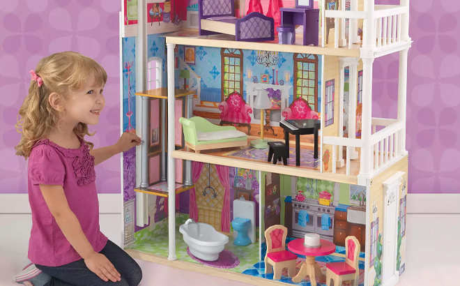 A Girl Sitting Next to the KidKraft My Dreamy Dollhouse