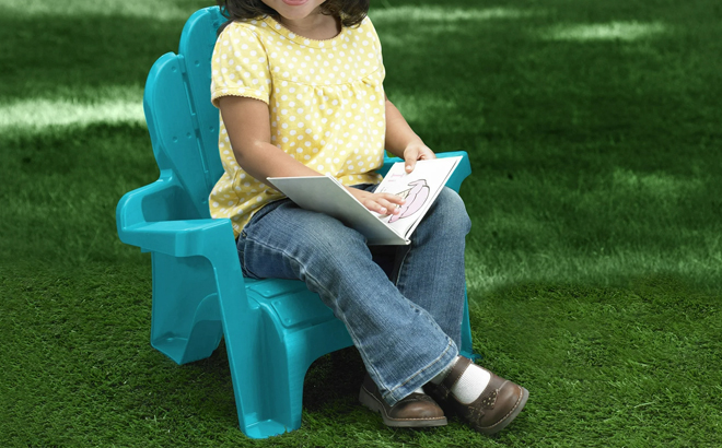 A Little Girl Sitting on a Childrens Adirondack Chair