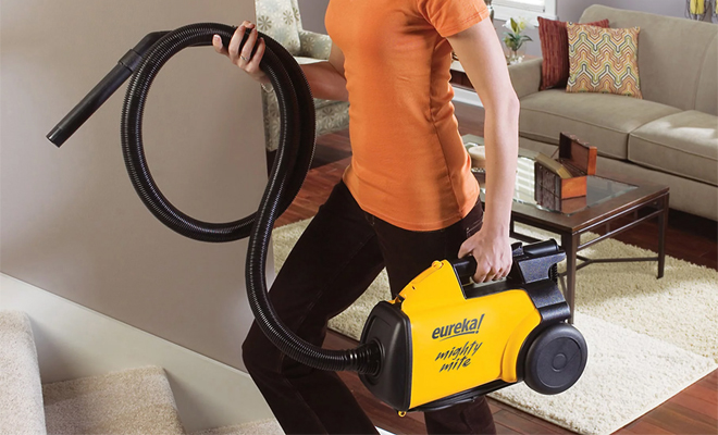 A Person Carrying the Eureka 3670G Mighty Mite Lightweight Canister Vacuum