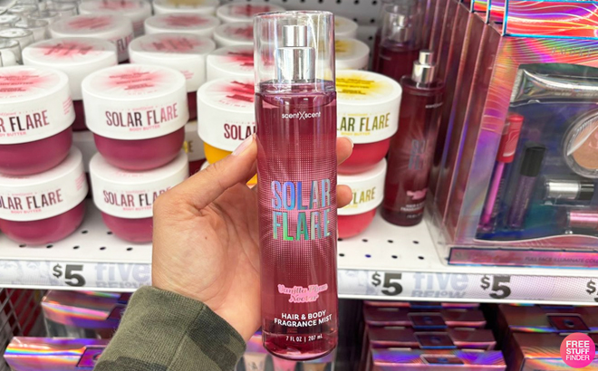 A Person Holding Solar Flare Hair Body Fragrance Mist in Plum