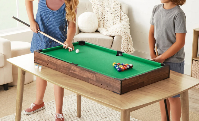 A Person Playing on the Tabletop Billiard Set